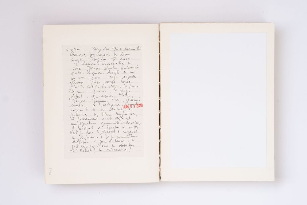 Open notebook with handwritten notes in black ink on left page, right page blank, red stamp visible.