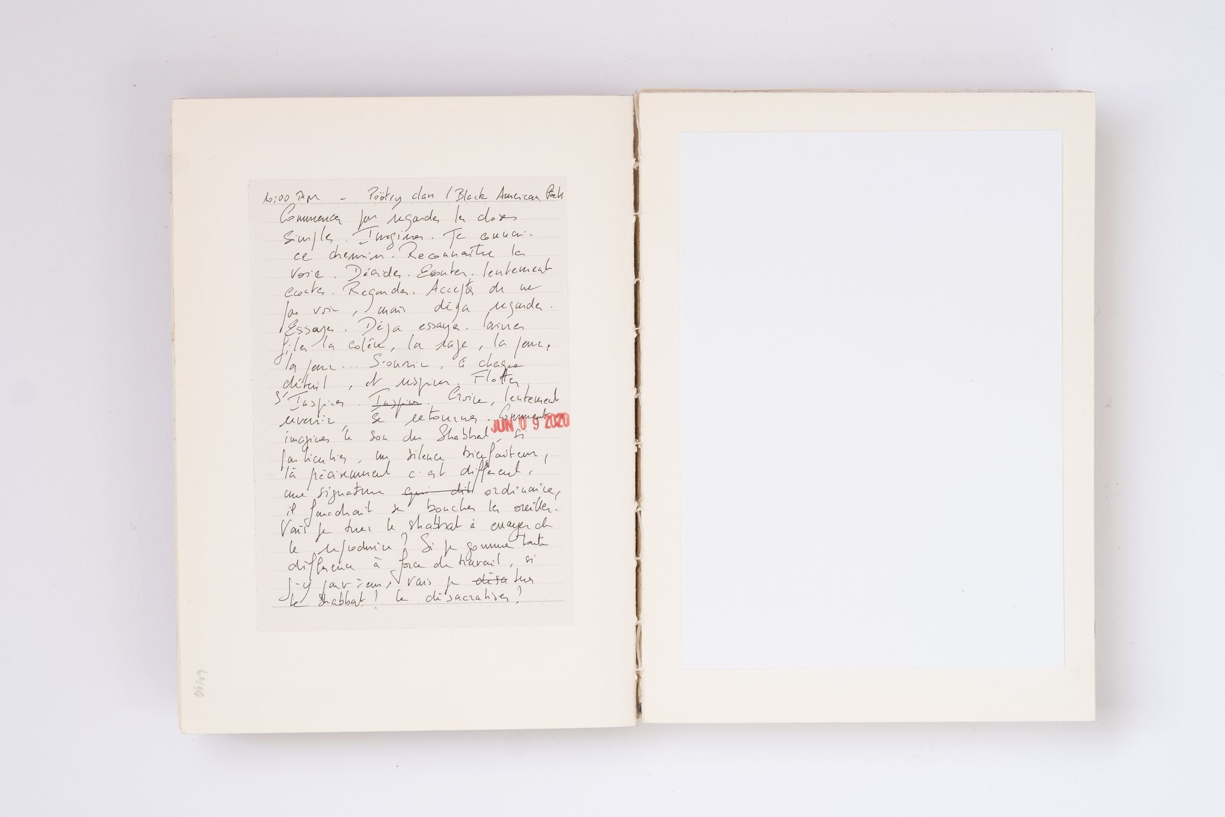 Open notebook with handwritten notes in black ink on left page, right page blank, red stamp visible.