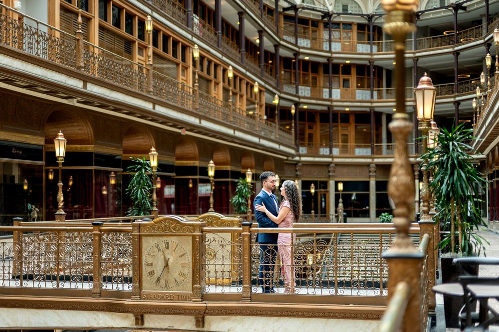 Couple sharing a romantic embrace on a ornate balcony inside the historic Arcade building in Cleveland, Ohio.