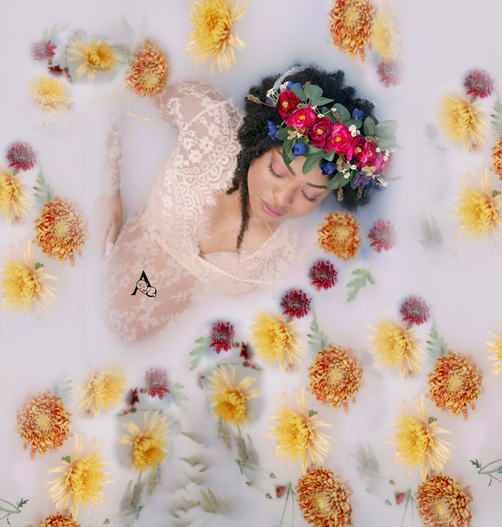 Artistic floral milk bath maternity portrait with yellow blooms.