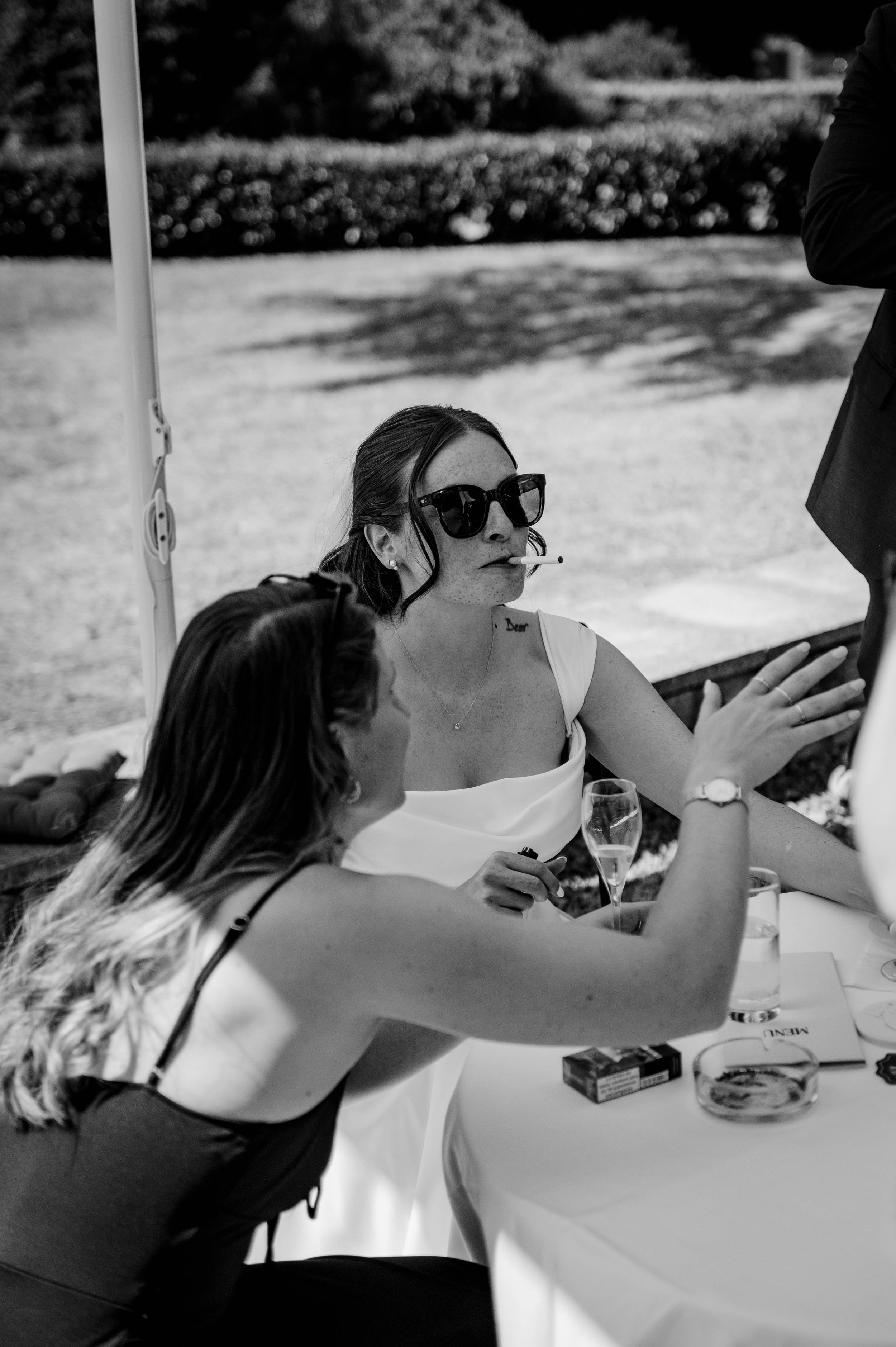 Moment spontané de la mariée pendant le repas de mariage, photographié en noir et blanc.