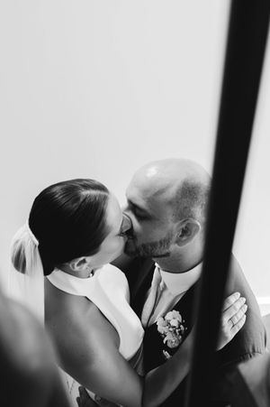 Moment intime en noir et blanc entre les mariés photographiés à travers un miroir.