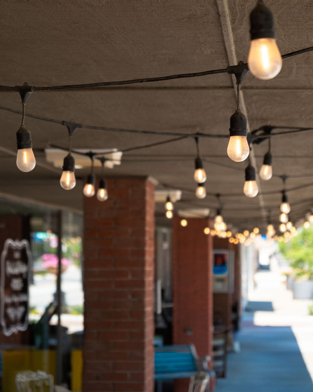 Outdoor string lights hang above the sidewalk in downtown Sapulpa, OK. June 10, 2026. (David J. Manning)