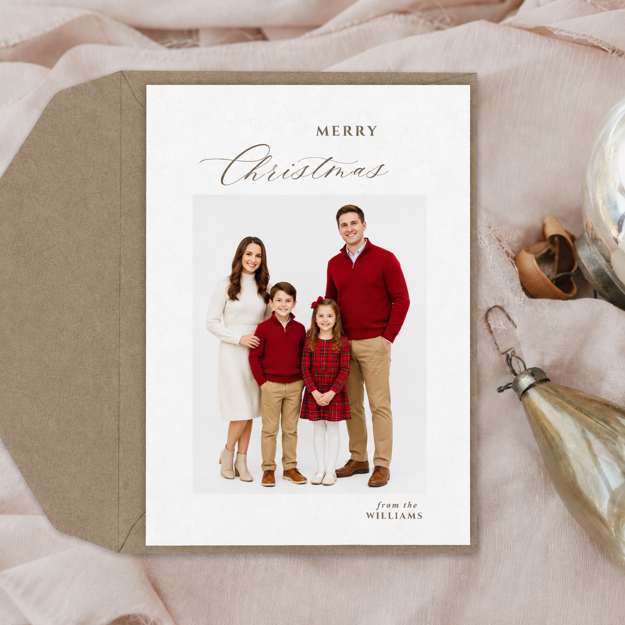 Elegant Christmas card featuring a family of four in red and white outfits with Merry Christmas text. Elizabeth Lang Photograpy