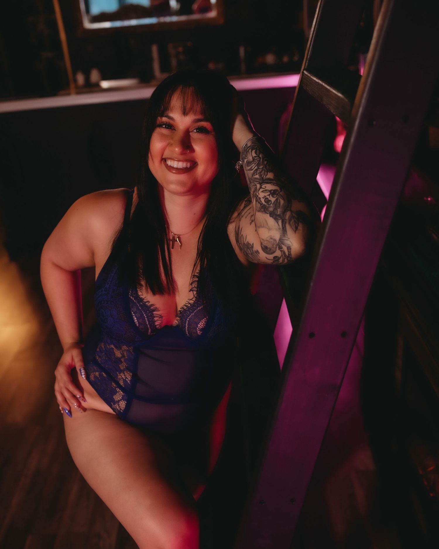 confident woman posing on a ladder at her boudoir photoshoot in spring hill florida