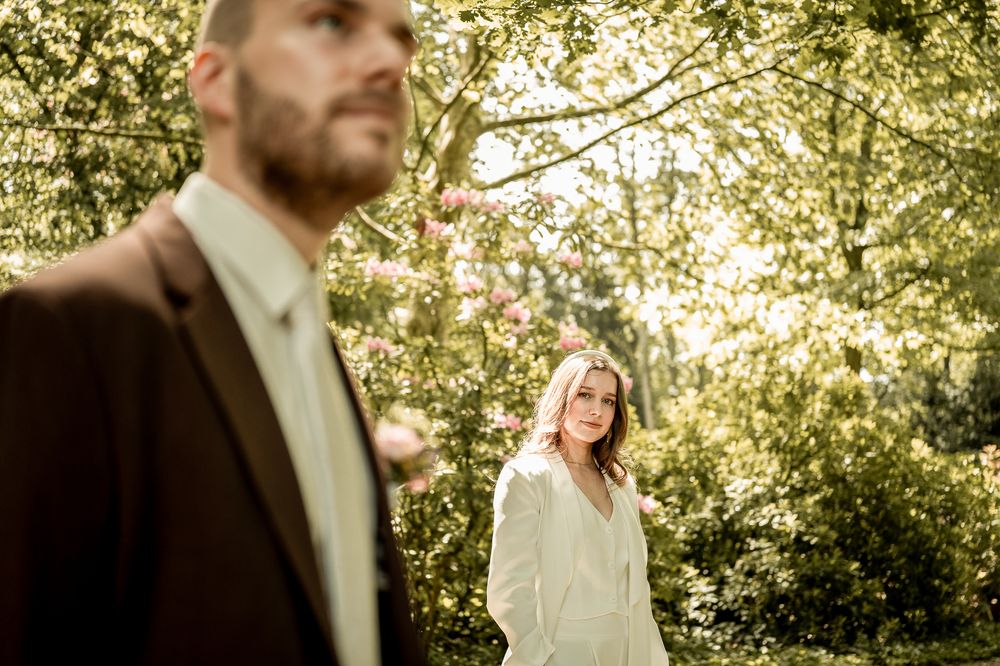 Brautpaar beim romantischen Spaziergang im Park von Schloss Moyland, natürliche Hochzeitsfotografie.