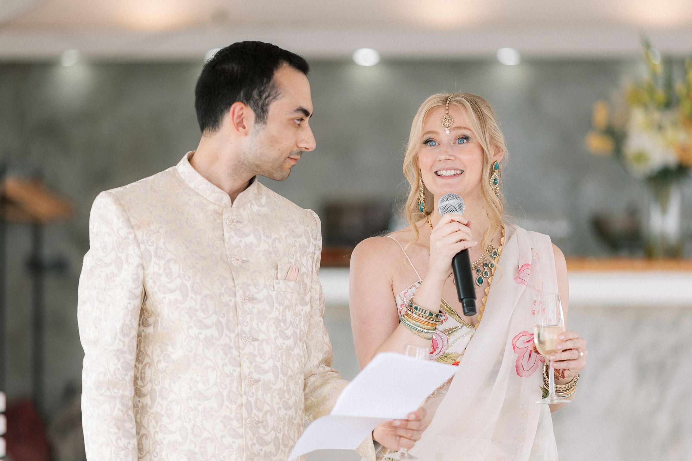 Bride and groom sharing speeches during their Mehndi and Sangeet celebration overlooking the Atlantic Ocean.