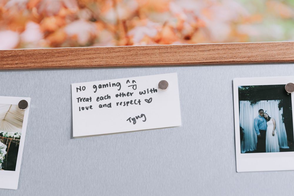 Handwritten note on bulletin board reads No gaming, treat each other with love and respect, signed Tying.