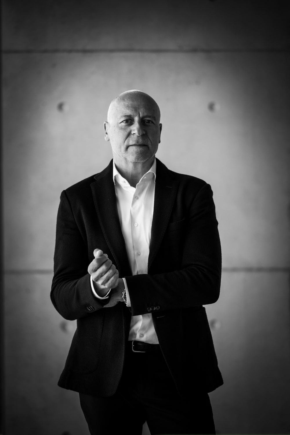 Businessporträt eines Mannes im weißen Hemd und Sakko, der den Jackenärmel hochzieht, fotografiert für GELSEN-NET in Gelsenkirchen
