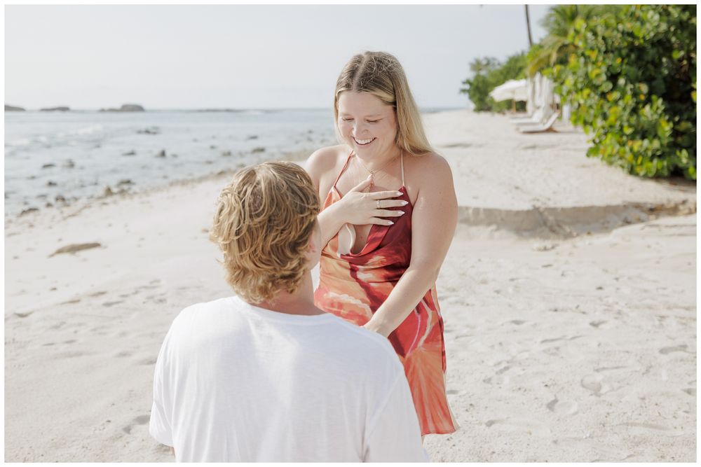 Punta Mita Couple Photo Session featuring a couple sharing a joyful moment on a tropical beach with turquoise water in the background.