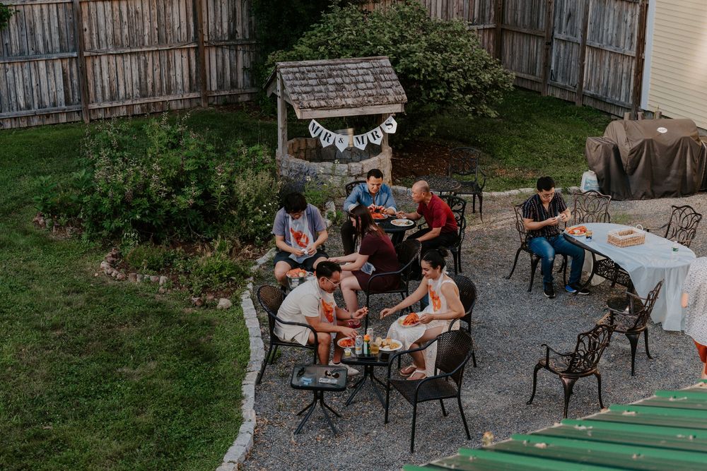 Wedding guests gather on a patio for an intimate outdoor evening gathering at a rustic barn venue.