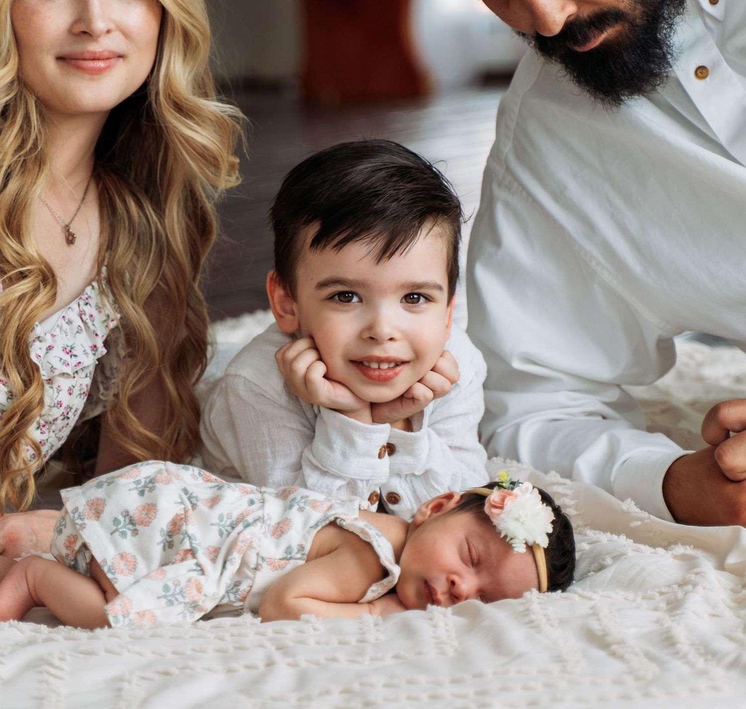 Big brother smiling beside his newborn baby sister during a family photography session. West TN
