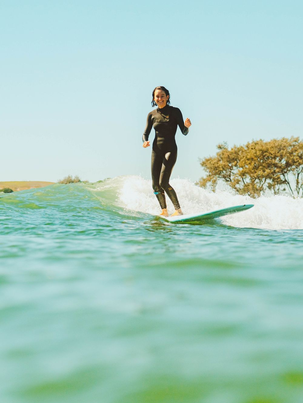 Girl smiling on a wave with Sunlight surfers Newcastle women's surfing group at Crescent Head Surf Camp out