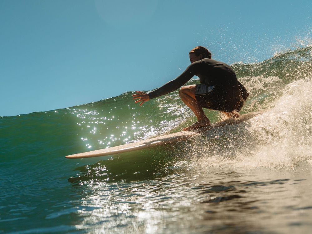 Girl crouching low on a wave with Sunlight surfers Newcastle women's surfing group at Crescent Head Surf Camp out