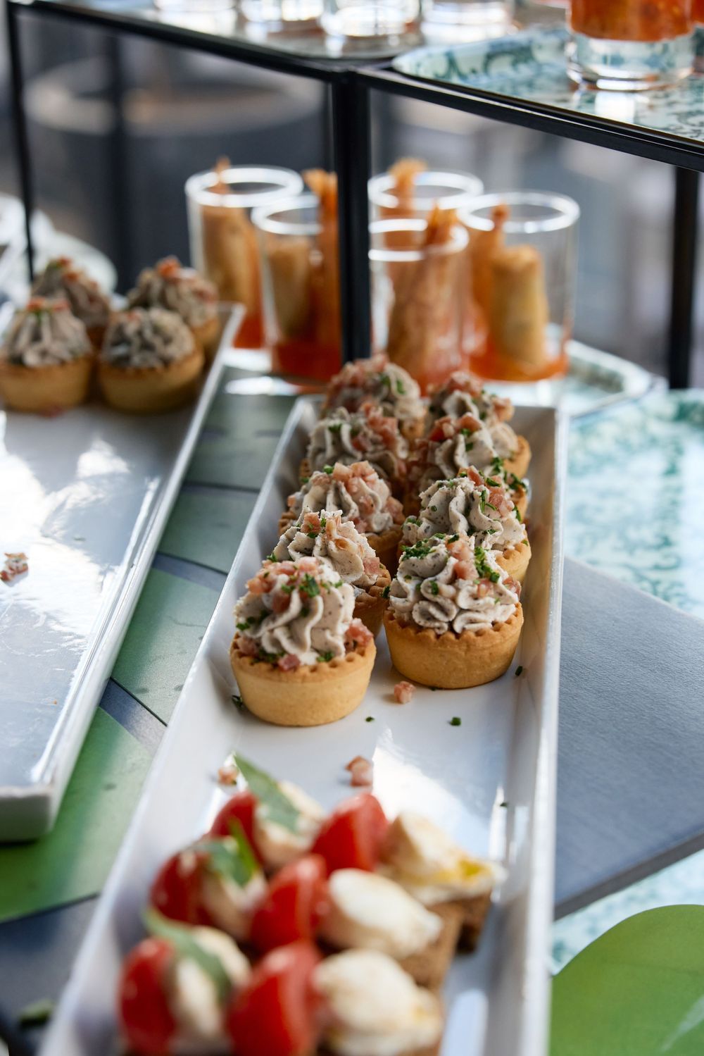 Assorted gourmet canapes and appetizers displayed on elegant catering tray at wedding reception.