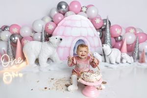 Baby girl smash cake photo with pink igloo, polar bears, balloons, and One neon sign winter wonderland theme.