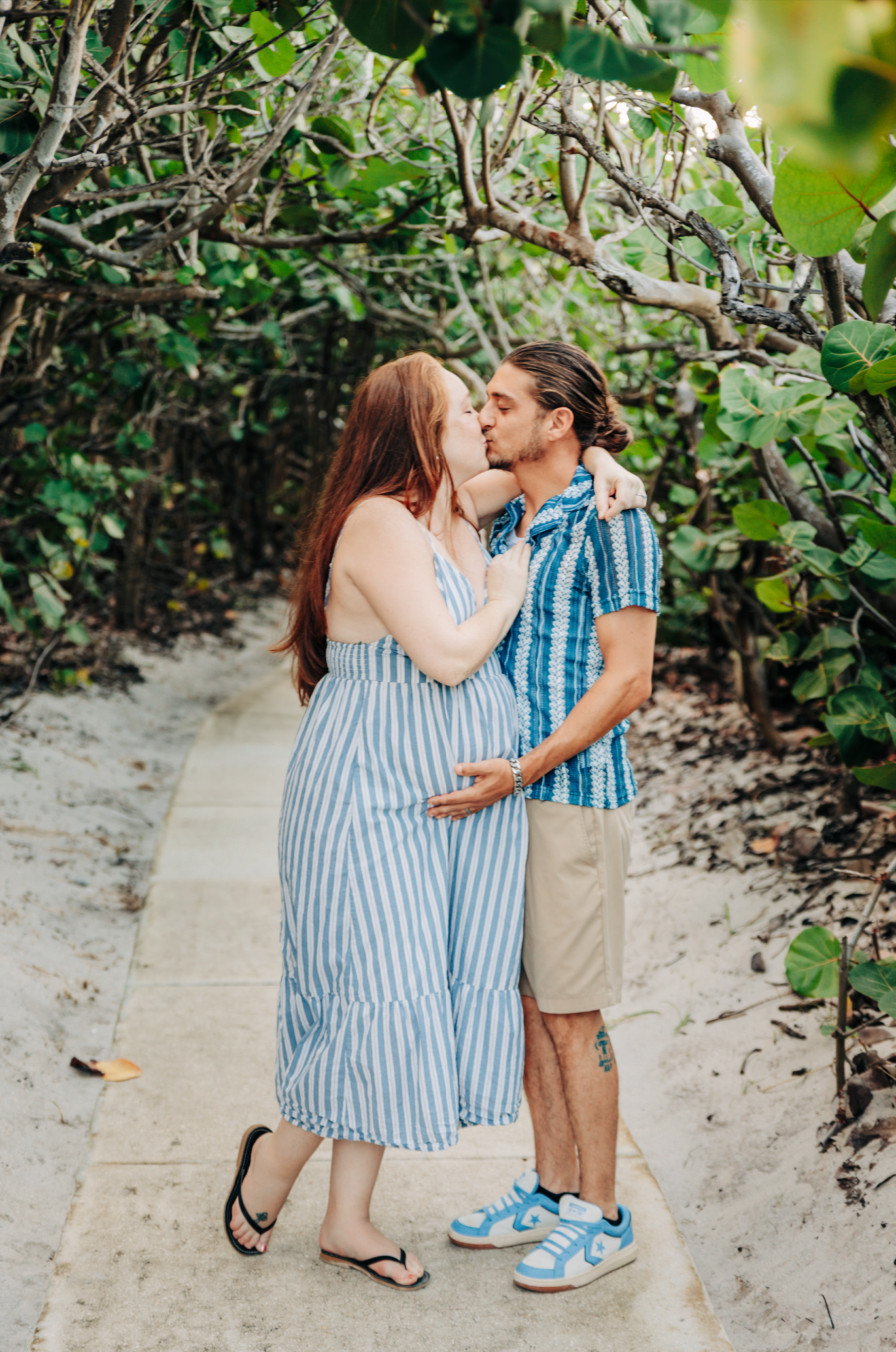 Maternity photographer Jupiter FL capturing an expecting couple on the sea grape path at Coral Cove Beach.