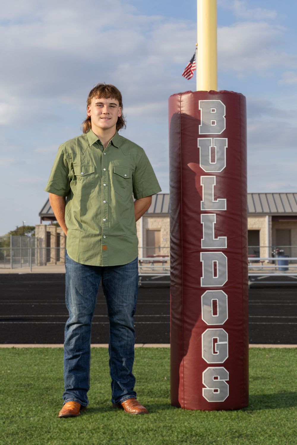 young adult male standing next to goal post