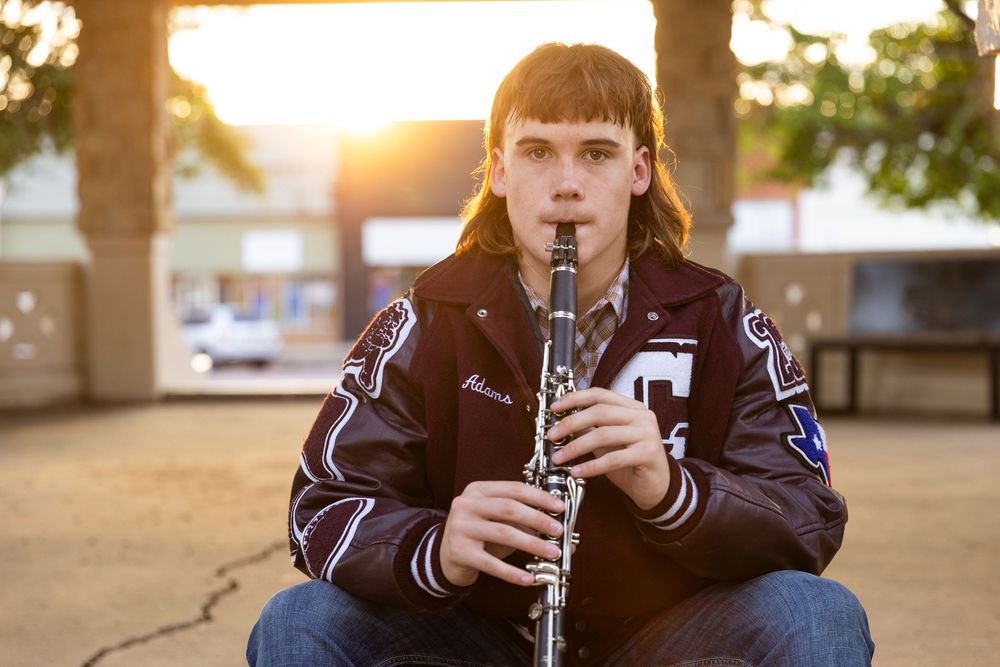 close up image of a young man holding his clarinet to his lips as if getting ready to play