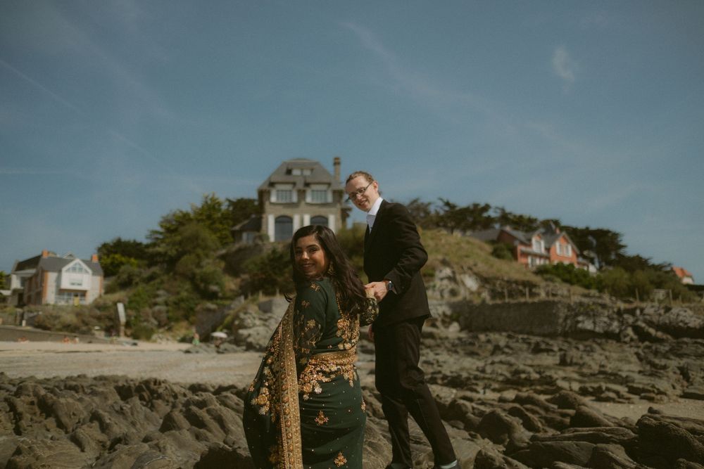 Bride and groom on the beach during couple shoot on the coast of france.