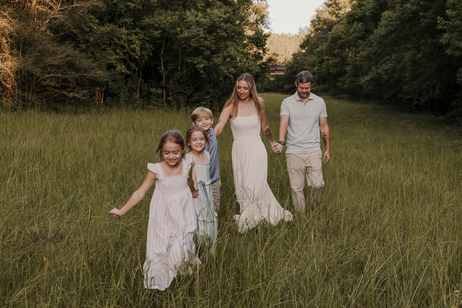 Family walking together outdoors during a Dahlhouse Images session.