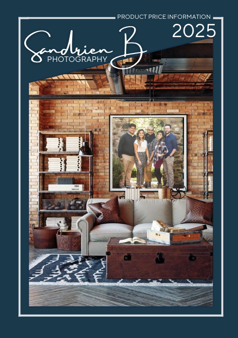 2025 photography pricing catalog cover showing rustic interior with exposed brick wall, wooden shelving and gray armchair.