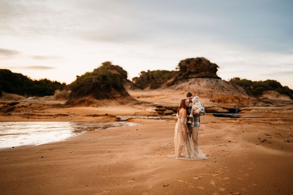 Family connect together on scenic sandy beach with dramatic coastal landscape at sunset in the Sutherland Shire