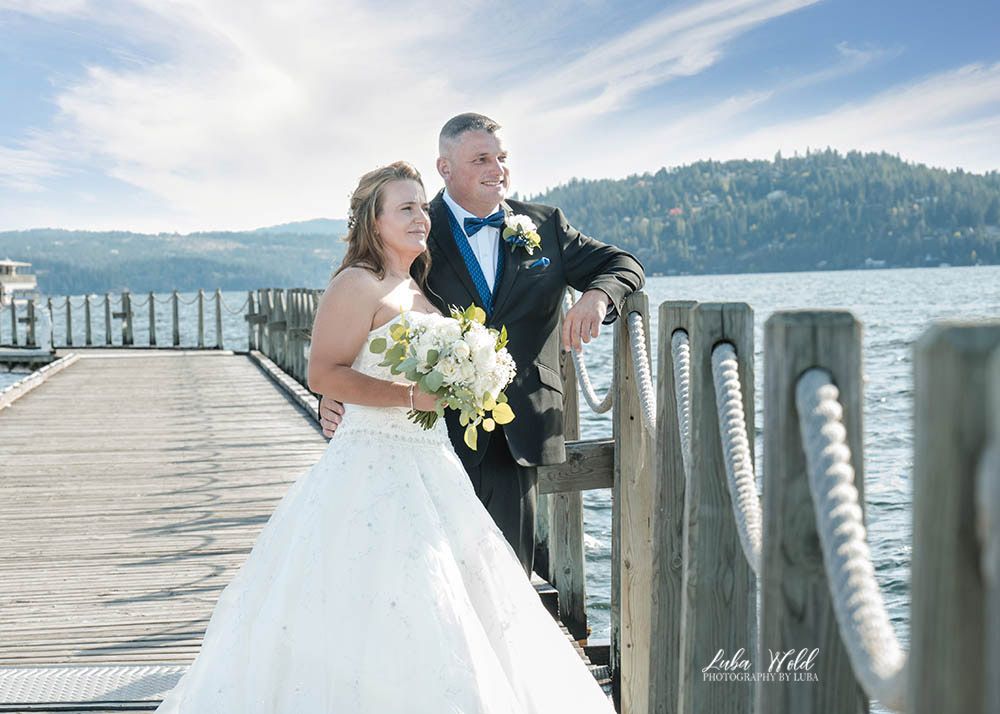 summer romantic wedding portrait of bride and groom on boardwalk on lake Coeur d Alene by photographer Luba Wold