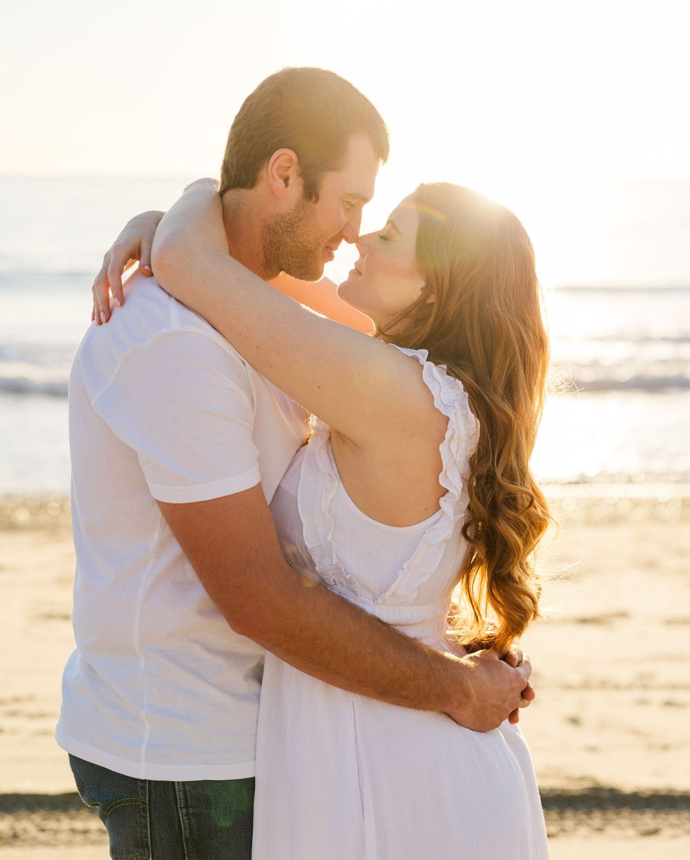 Engaged couple sharing a quiet moment on the beach in San Clemente