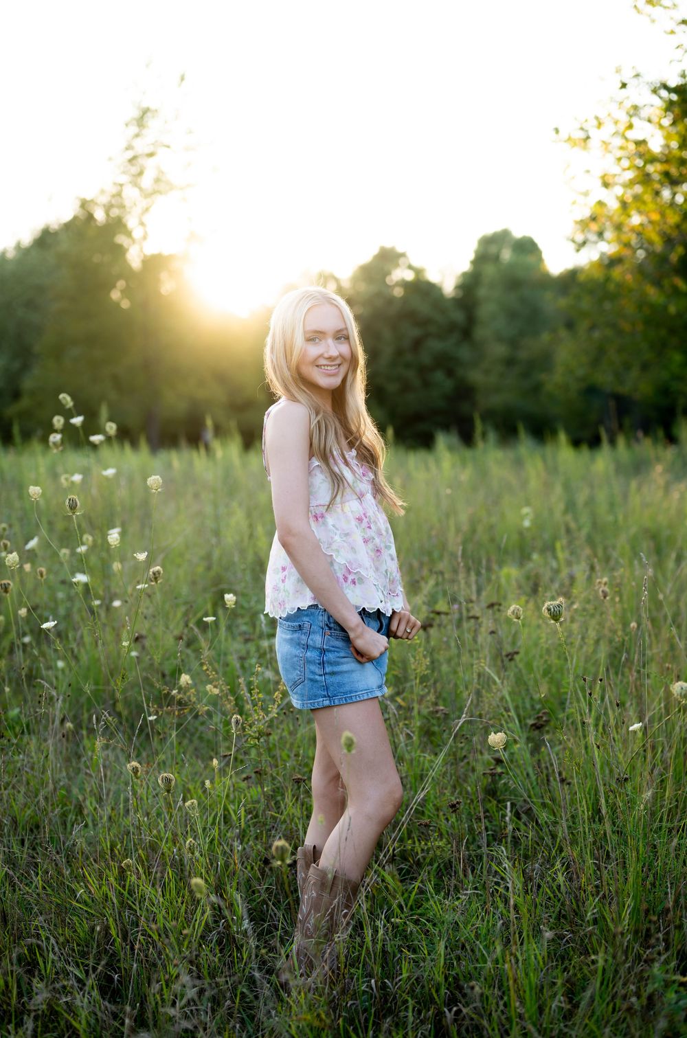 Casual summer portraits in a wildflower field during sunset wearing denim shorts.