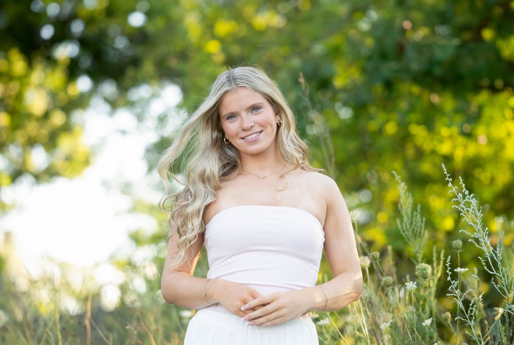 Ethereal outdoor photography with soft natural lighting and wildflowers in the background.