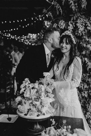 Black and white wedding photos show intimate moments with floral arrangements and string lights creating a romantic atmosphere.