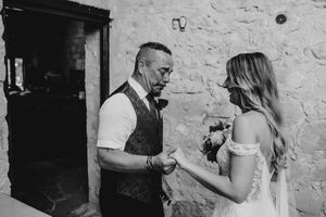 A black and white photo of a tender moment between a couple during a wedding celebration.