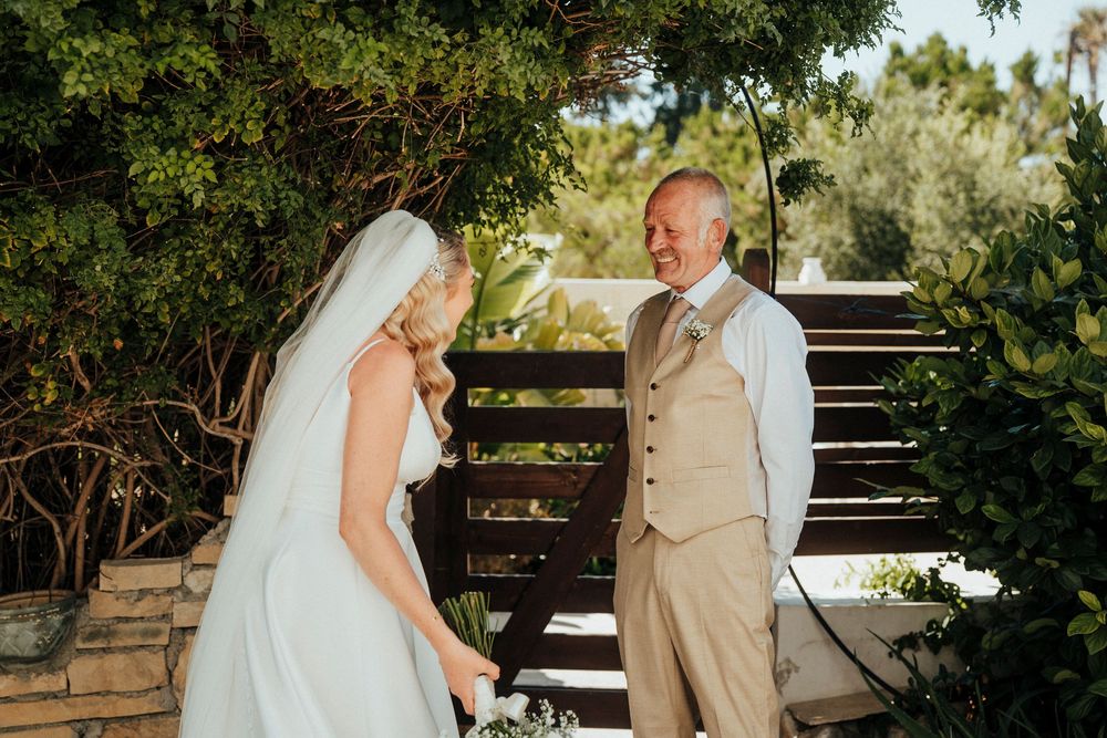 A wedding couple shares tender moments in a lush garden setting during their special day.