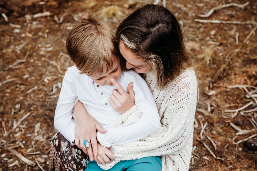 Mom and little boy in white hugging in field in Dickson, TN