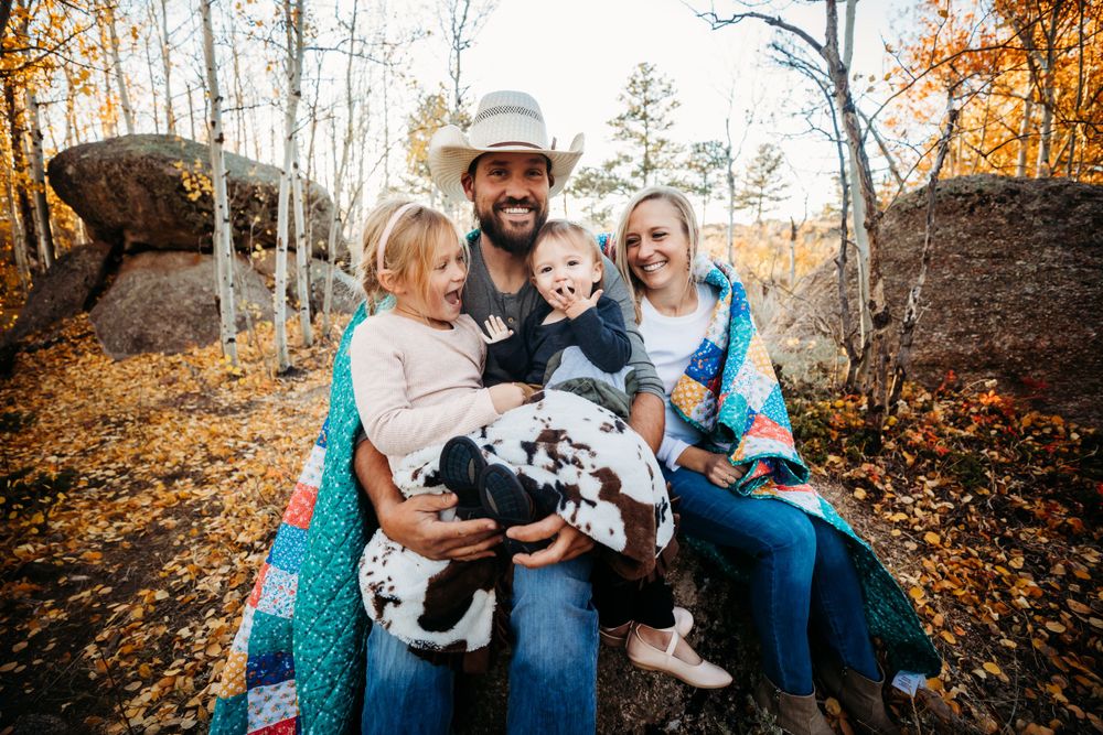 Mom, Dad, daughter, and son wrapped in blankets smiling at the camera in the mountains Dickson, TN
