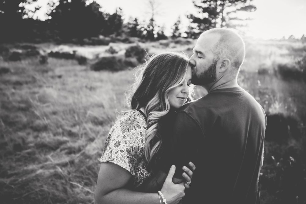 Husband kissing his wife's forehead in black and white in Dickson, TN