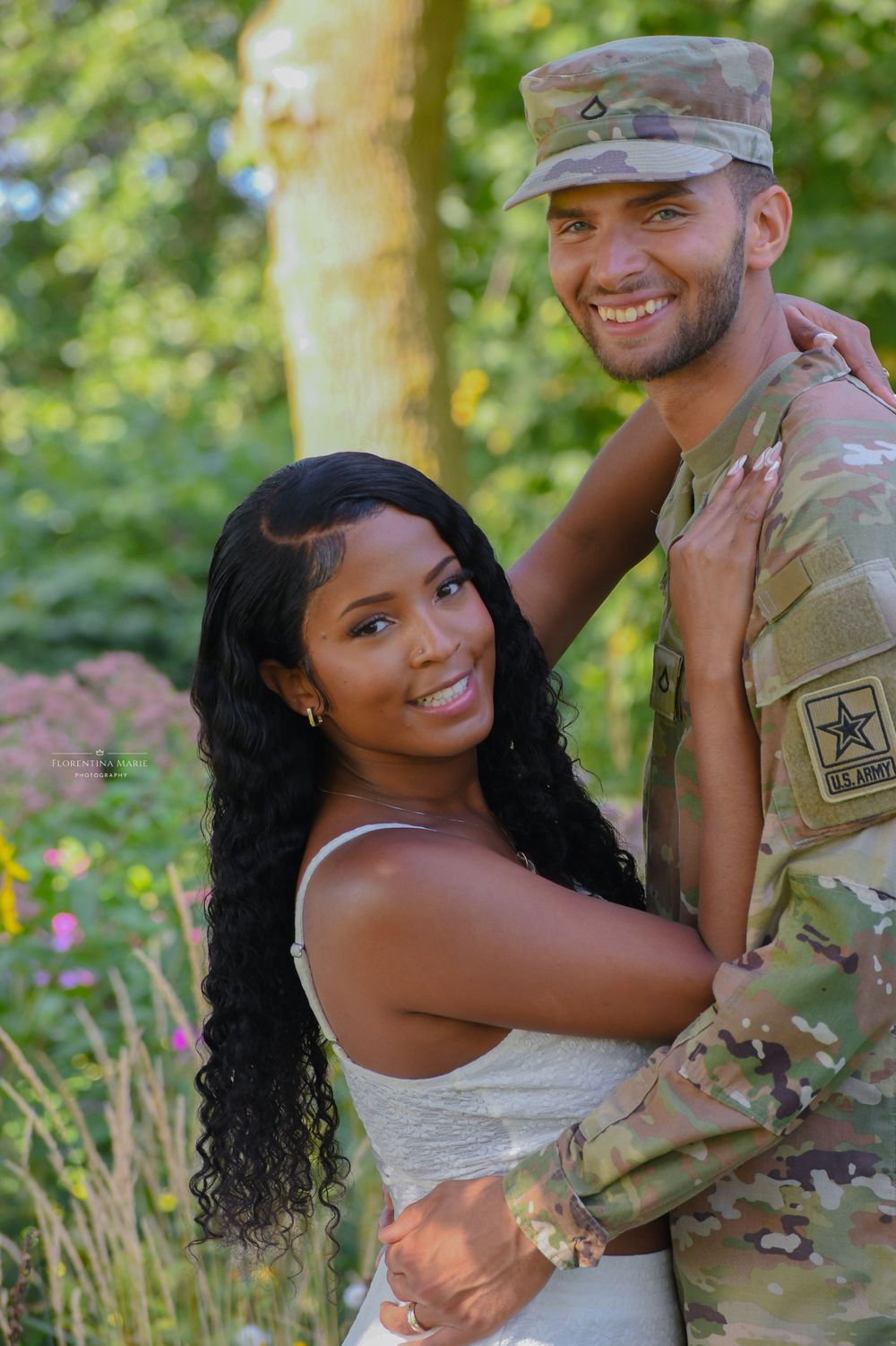 Outdoor portrait session featuring military uniform against floral garden backdrop.