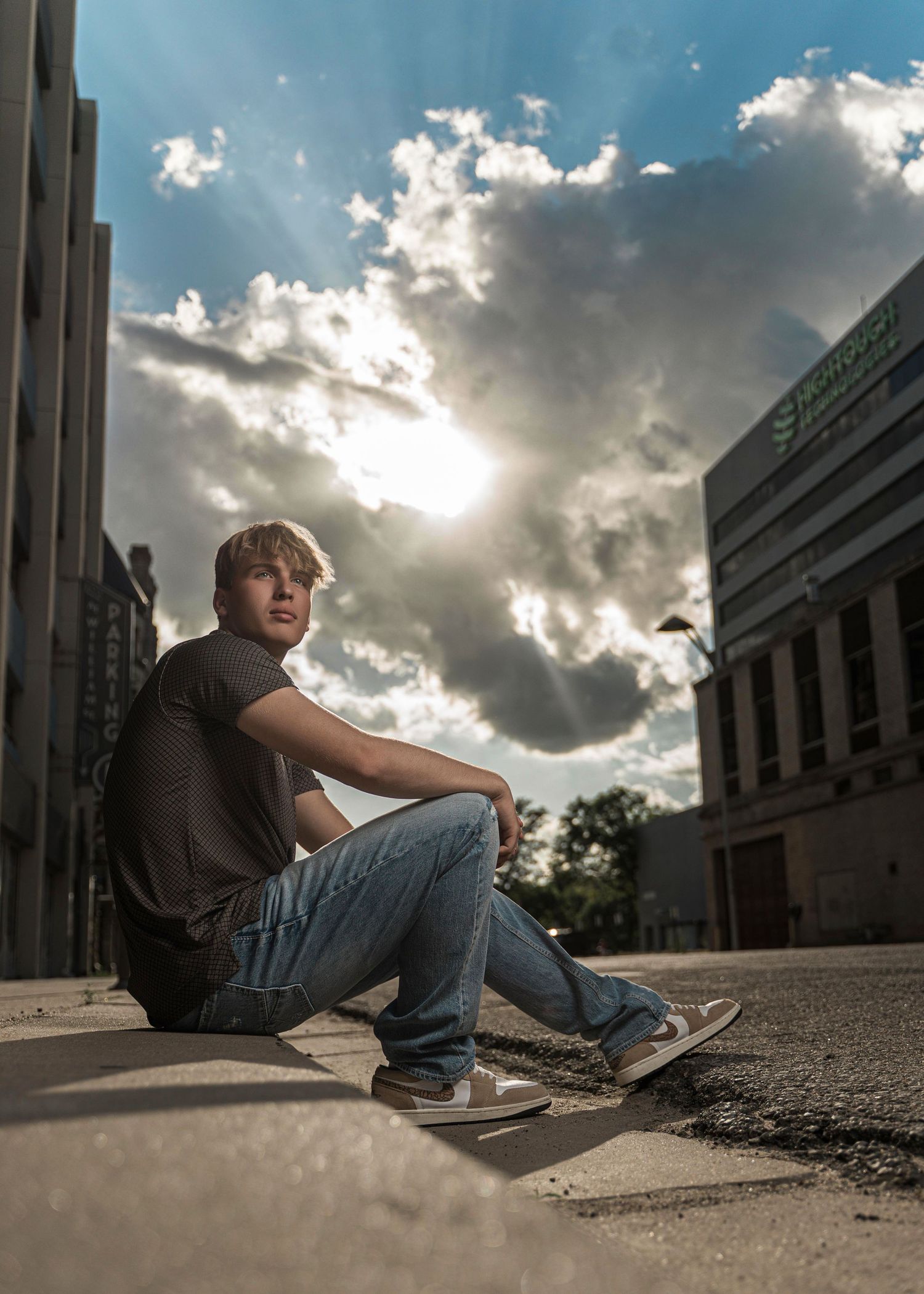 Skateboarder performs a sequence of sliding tricks on concrete ledge against dramatic cloudy sky.