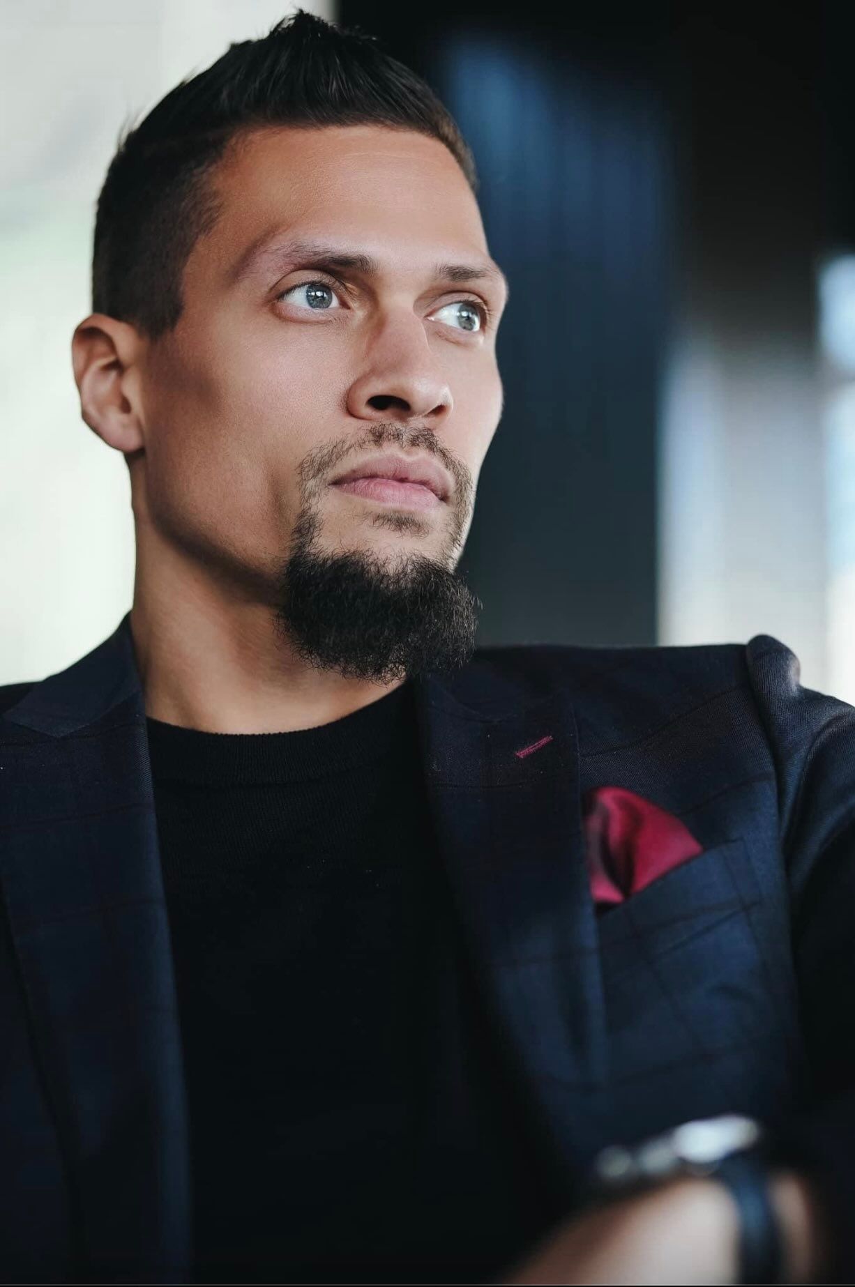 Close up headshot of wedding videographer Nate Templeton looking off in the distance in a dark navy suit