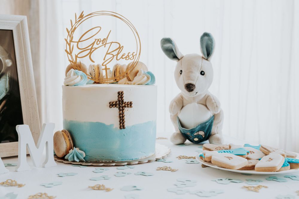 Baby shower decoration setup with blue cake and stuffed animals.