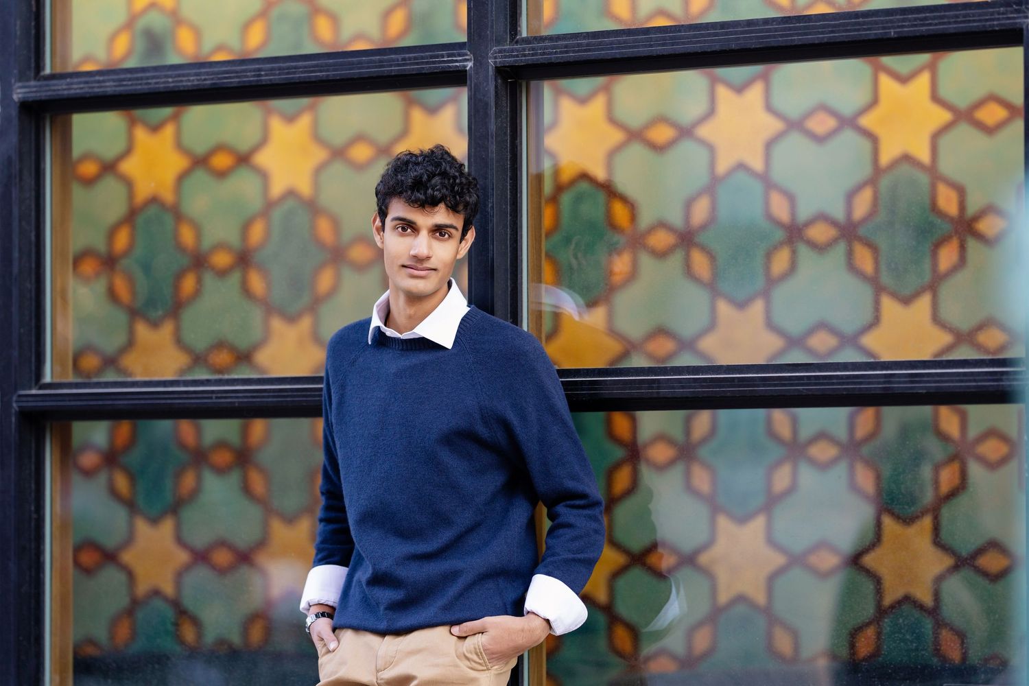 Senior photo of a boy smiling, standing in front of a mural, shot by Milwaukee senior photographer Rachel Dickman.