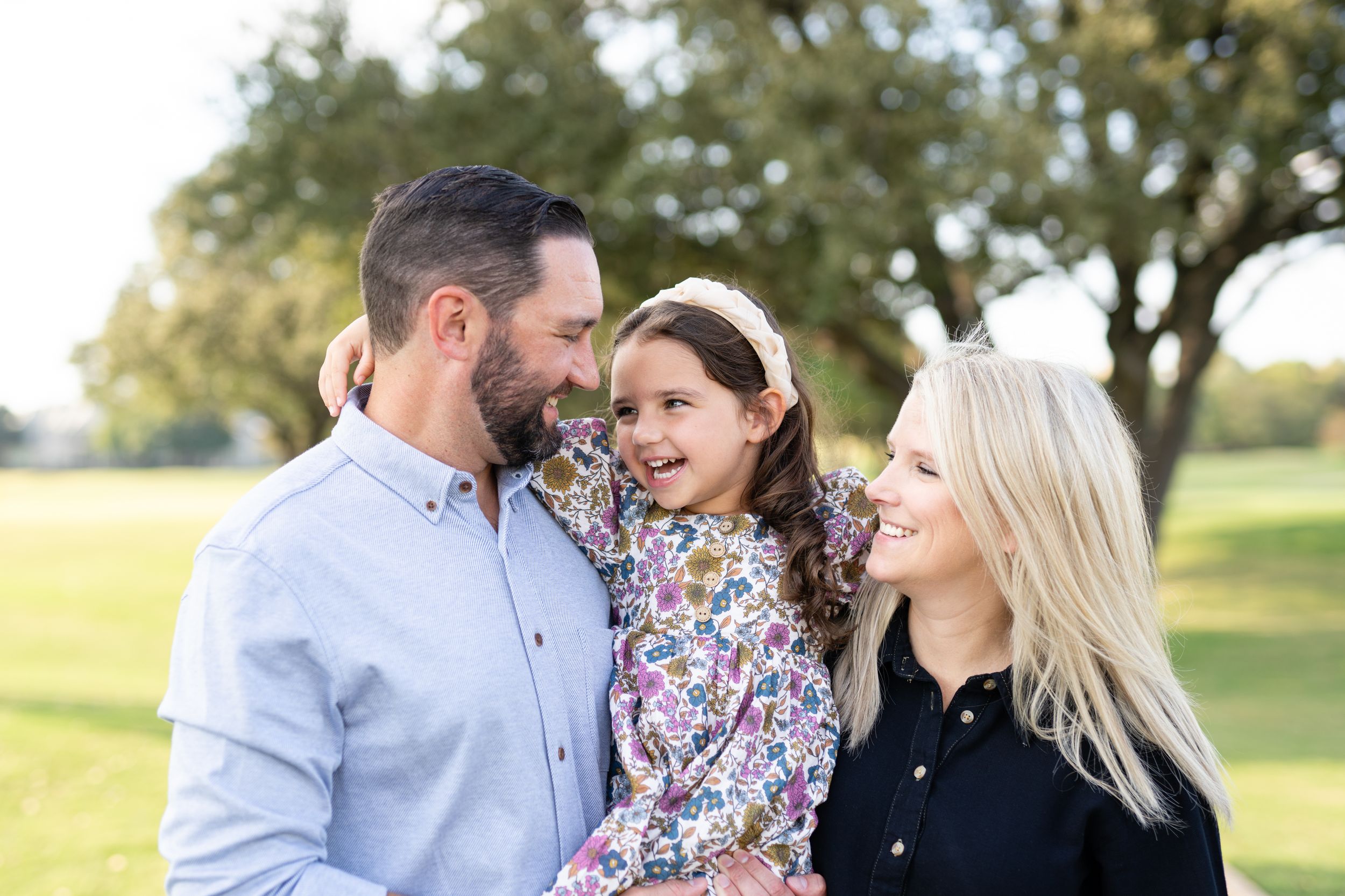 Happy family sharing joyful moment outdoors in a park on a sunny autumn day.