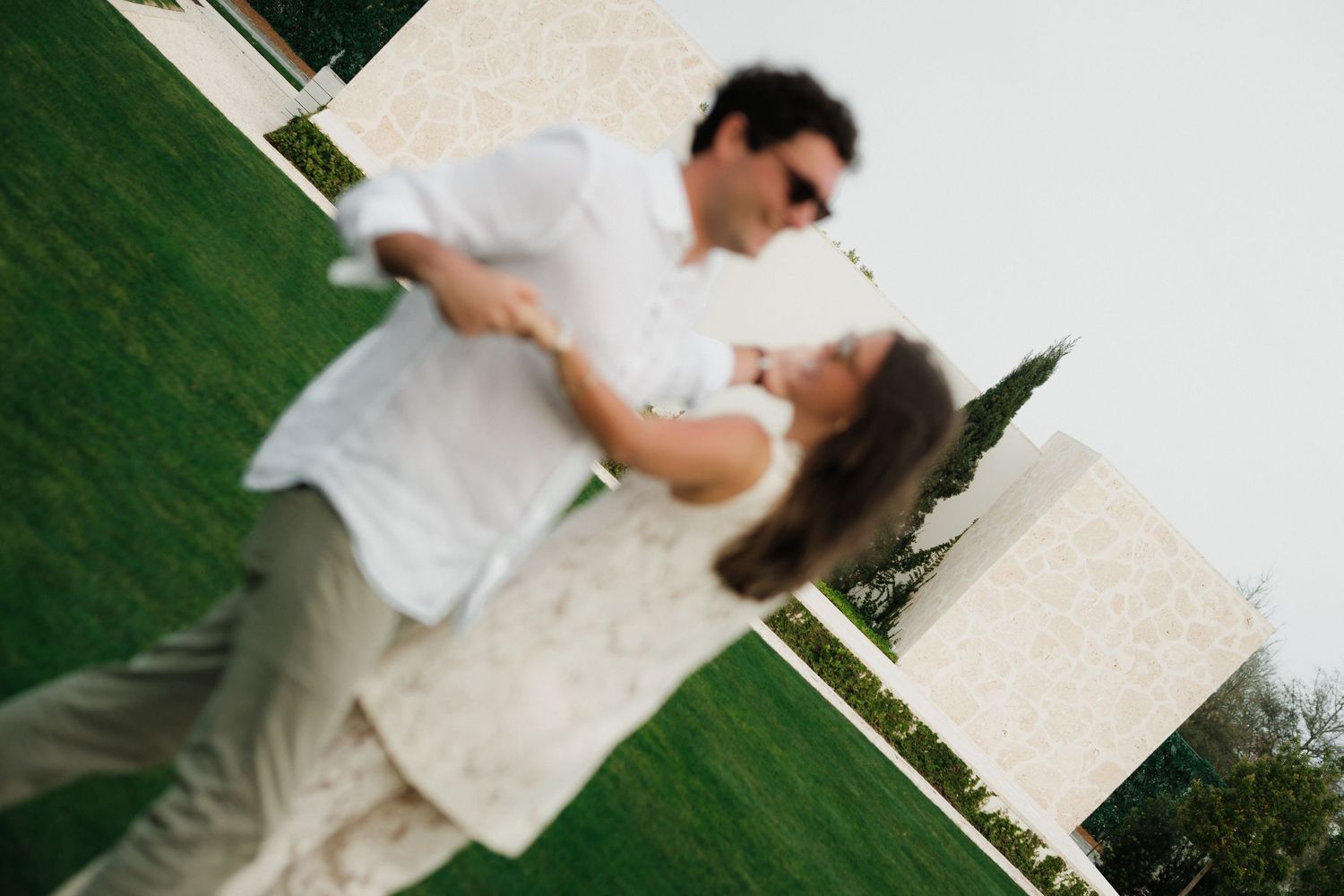 A blurred artistic photo of a couple embracing outdoors.