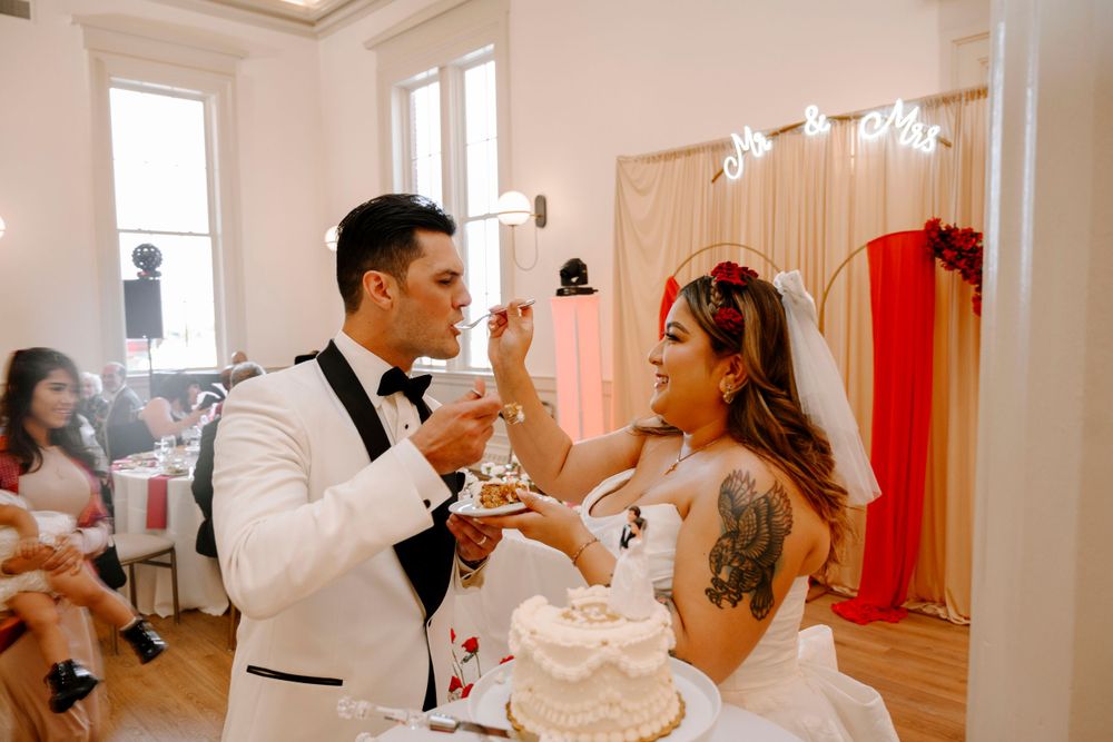 A couple splits a piece of wedding cake during their reception celebration.