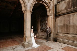 Bride and groom share a quiet moment under a grand stone archway at Bethesda Terrace, Central Park.