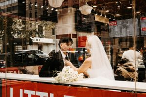 Bride and groom share a romantic moment inside Little Italy Pizza restaurant on their wedding day.