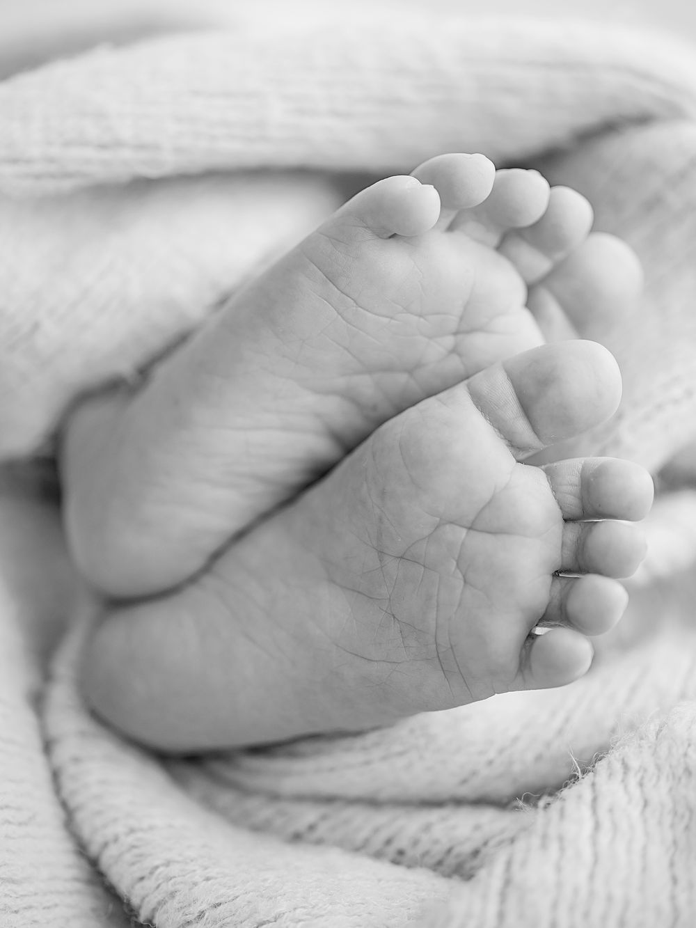 detaljbild på bebisfötter nyfödd bebis i svartvitt, nyföddfotografering i Västerås, memoriesbym.se