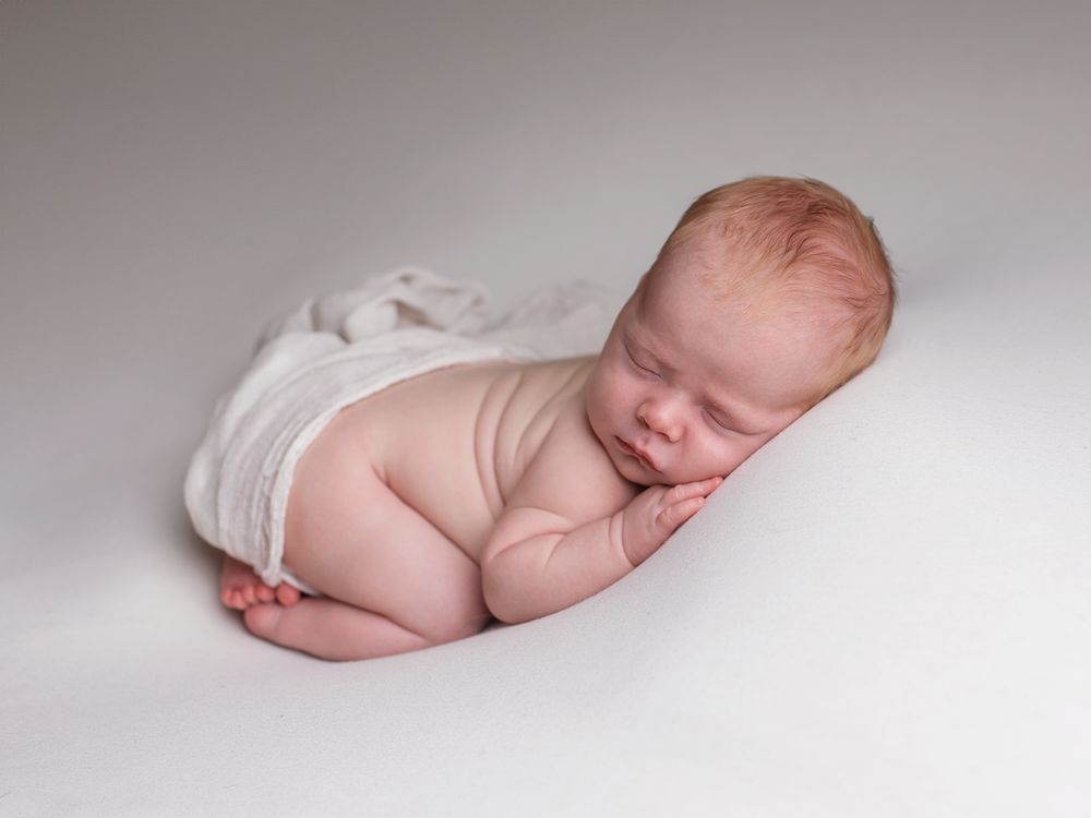 Nyfödd bebis sover på mage, nyföddfotografering Västerås, MemoriesbyM