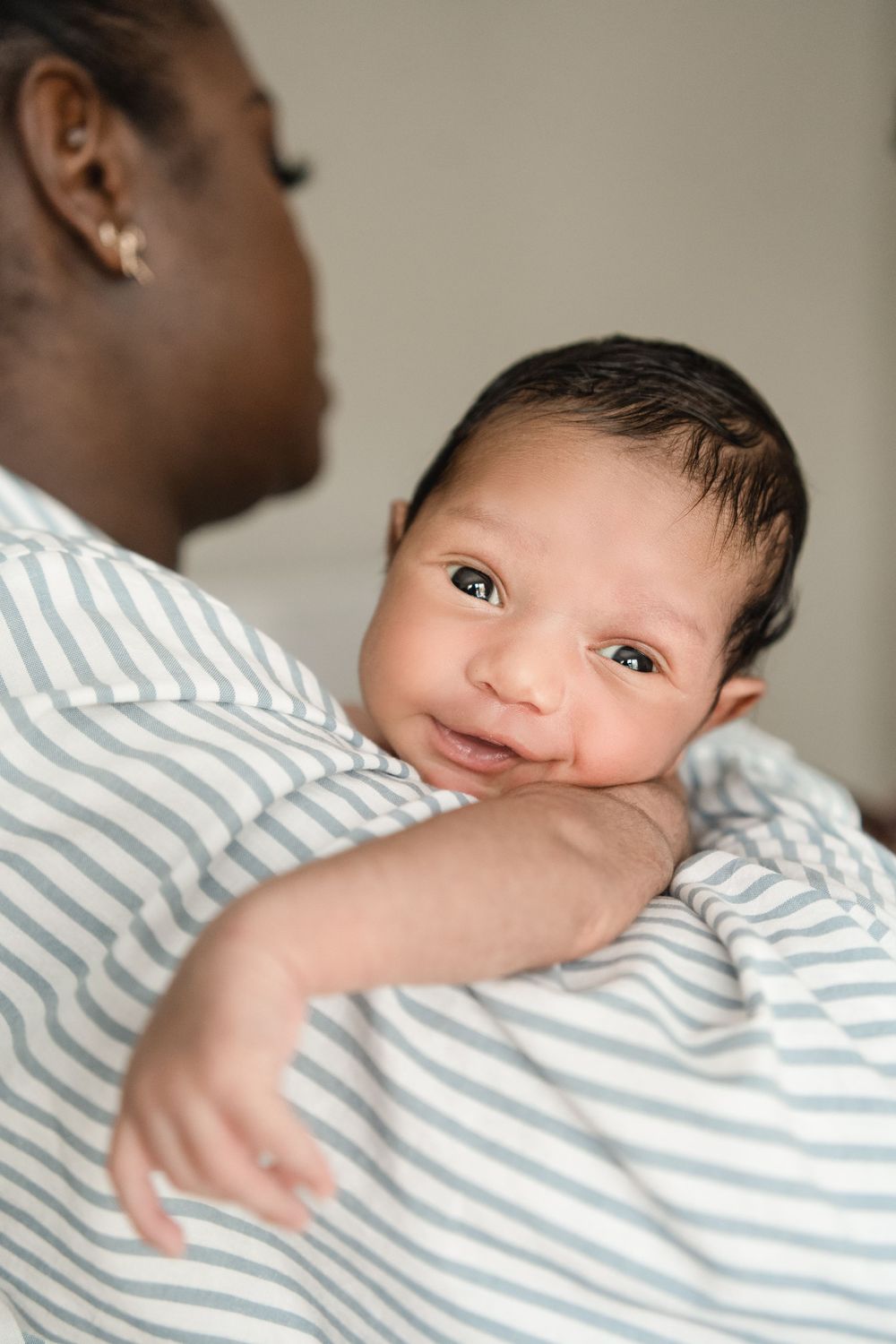 Newborn baby boy in Marietta GA smiling on his dad's shoudler